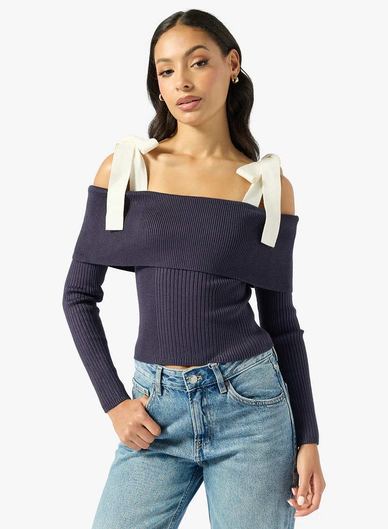 جس كنزة بكتف مكشوف وأكمام طويلة